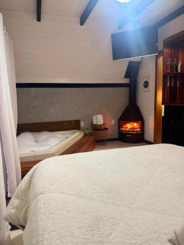 a bedroom with a bed and a fire place at Chalé do amor, sítio pousada vô Maneca in Timbó