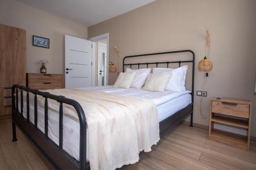a bedroom with a large bed with white sheets and pillows at Monte Vista in Bansko