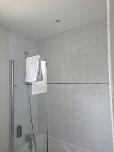 a white bathroom with a shower and a bath tub at The Originals City, Hôtel Le Savoy, Caen in Caen