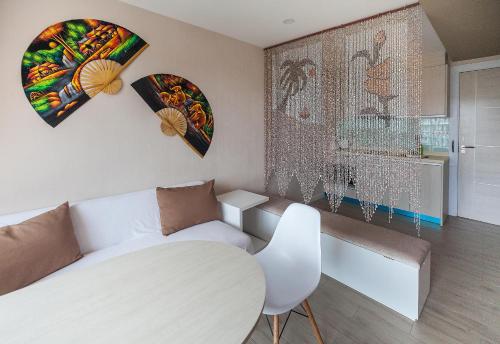 a living room with a white couch and paintings on the wall at 7Seas in Jomtien Beach
