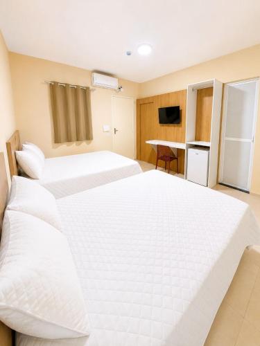 a hotel room with two beds and a kitchen at Pousada Milagres in Canindé