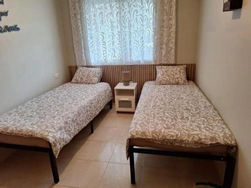 two beds in a small room with a window at Apartment Miami Platja 80 m² Pool in Miami Platja