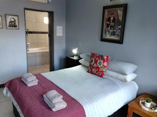 a bedroom with a bed with towels on it at Wildebeespan Guest Farm in Delareyville