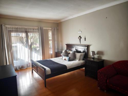 a bedroom with a bed and a chair and a window at Stay & unwind in Alberton