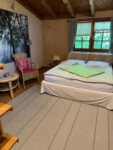 a bedroom with a large bed and a chair at Gästeappartement Appricot in Adendorf