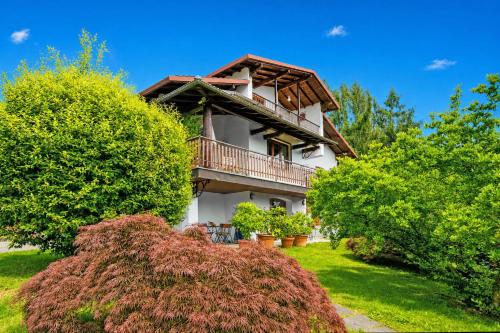 a house with a balcony in the middle of trees at Villa La Verbanina Private Garden - Happy Rentals in Ghiffa