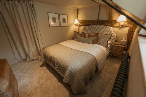 a bedroom with a large bed and a chair at Hathaway Hamlet in Stratford-upon-Avon