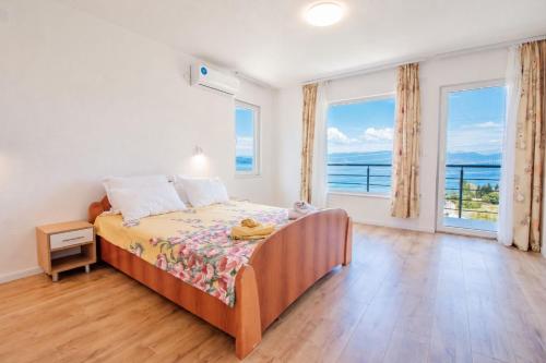 a bedroom with a bed with a view of the ocean at VILA NAUM in Ohrid