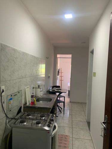 a kitchen with a stove and a sink at Fortal Flat in Fortaleza