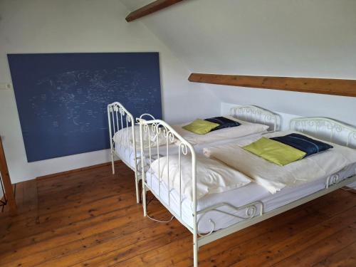 two twin beds in a room with a blue wall at Bed en Boterham in Hedel