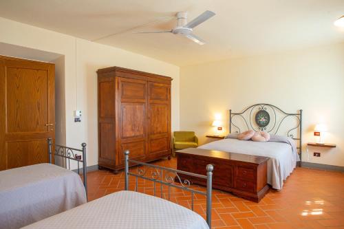 a bedroom with two beds and a dresser at Agriturismo Luggiano in Vinci