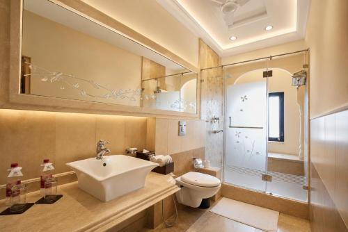 a bathroom with a sink and a toilet and a shower at Shahpura House in Jaipur