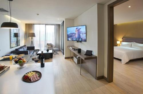 a hotel room with a bed and a living room at Grand Colony Hotel in Bogotá