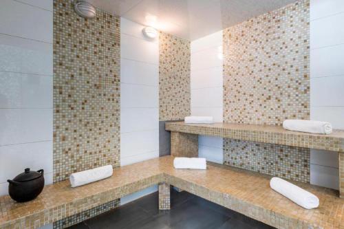 a bathroom with a counter with two sinks and towels at Grand Colony Hotel in Bogotá