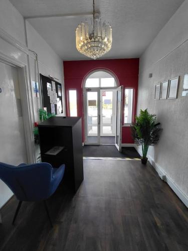 an office with a hallway with a chair and a chandelier at Harbour Stays in Skegness