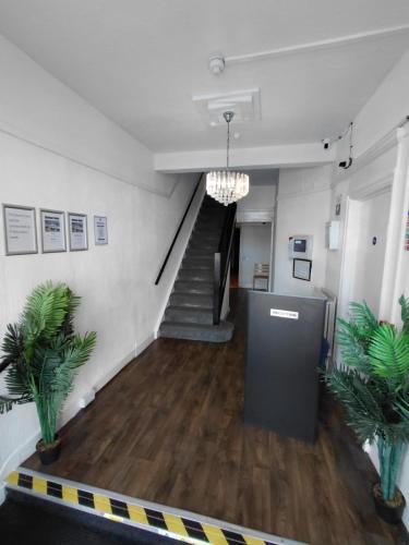 a hallway with a staircase in a building with plants at Harbour Stays in Skegness
