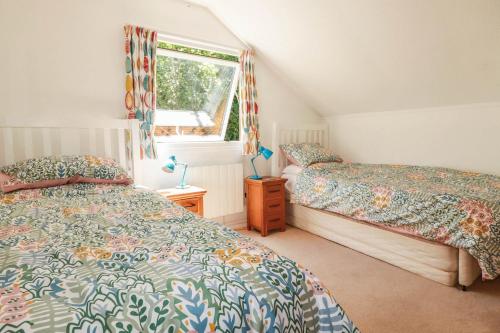 a bedroom with two beds and a window at Coombe Lodge No 9 in Bude