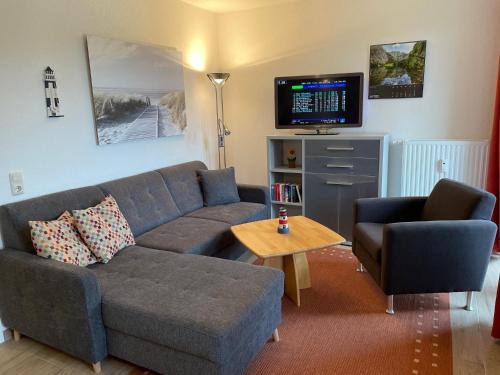 a living room with a couch and a tv at Haus Roland, Wohnung 16 in Zinnowitz