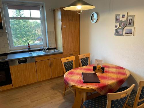 a kitchen with a table with a laptop on it at Haus Roland, Wohnung 16 in Zinnowitz