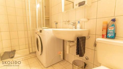 a bathroom with a sink and a washing machine at Apartment house Lötschberg in Naters