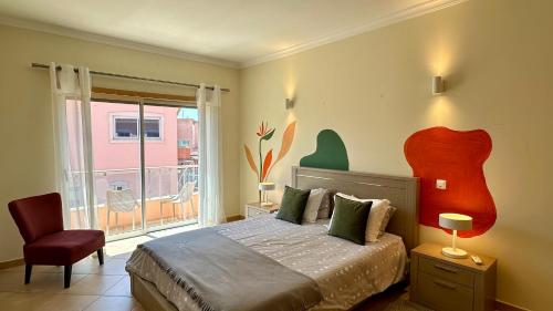 a bedroom with a bed and a chair and a window at Santa Maria N - Shared Pool - 8 Guests - Albufeira in Albufeira