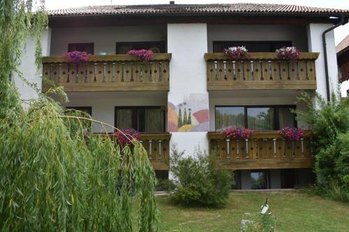 a building with two balconies with flowers on them at Sonnen Residence in Collalbo