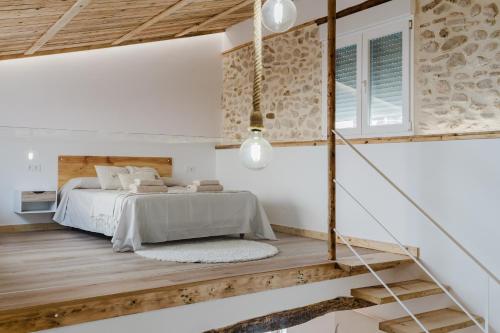 a bedroom with a bed and wooden floors at La cochera by Óscar Fuentes in Alcocer de Planes
