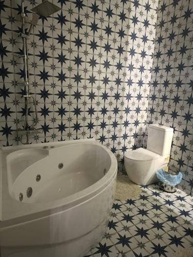 a bathroom with a white tub and a toilet at Menekşe Sultan Köşkü Otel Oda 2 in Burunabat
