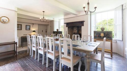 a dining room with a white table and chairs at Almsbury Farmhouse in Winchcombe