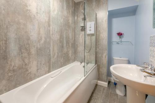 a bathroom with a white tub and a sink at 3 Bed in Bodmin oc-ltbra in Cardinham