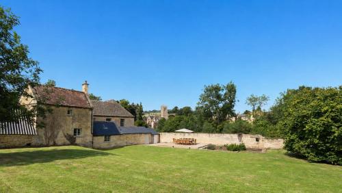an old stone house with a large yard at Almsbury Farmhouse in Winchcombe