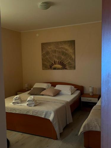 a bedroom with a bed and a painting on the wall at Apartments Roncevic #JOKO# in Gradac