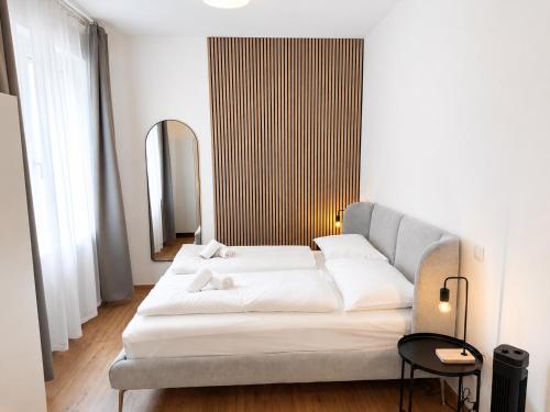 a white couch in a room with a mirror at Cosy Penzing Vienna in Vienna