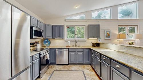 a kitchen with blue cabinets and a stainless steel refrigerator at Dewey Beach 102 Jersey St in Dewey Beach