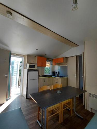 a small kitchen with a table and a refrigerator at Le petit paradis de la roque d'antheron in Jean-Jean