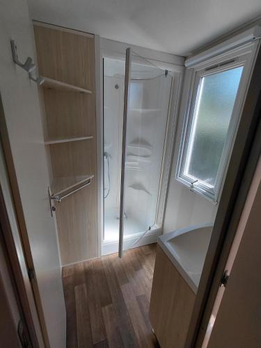 a walkin closet with a white refrigerator and a window at Le petit paradis de la roque d'antheron in Jean-Jean