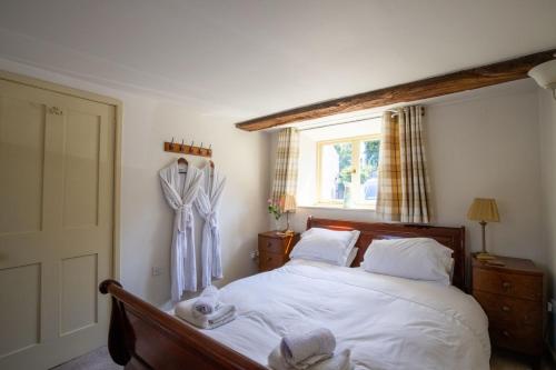 a bedroom with a bed with white sheets and a window at The Forge in Bakewell