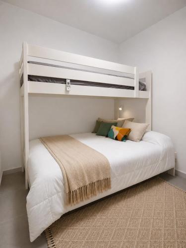 a white bed in a white room with a bunk at Los cántaros Apartamento Mojácar in Mojácar