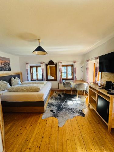 a bedroom with a bed and a desk and a television at Unterhecherhof in Bannberg
