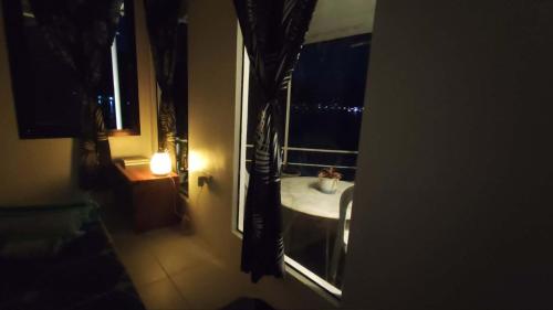 a bathroom with a window with a sink and a table at Anchor Doods in Romblon