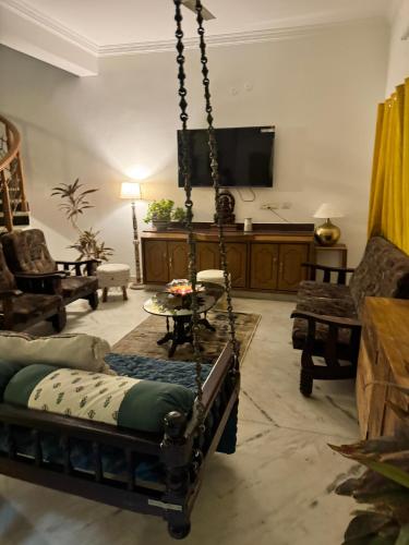 a living room with a swing and a tv at Fernwood stays in Haidar Sāhibgūda