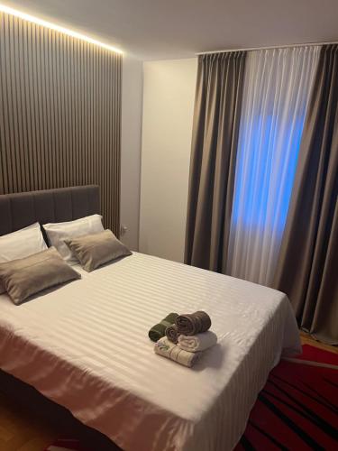 a bed with two towels on it with a window at Drina Lake House in Zvornik