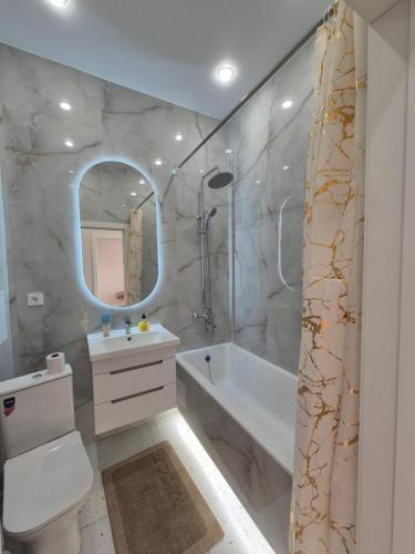 a bathroom with a tub and a toilet and a sink at ЖК Geneva in Astana