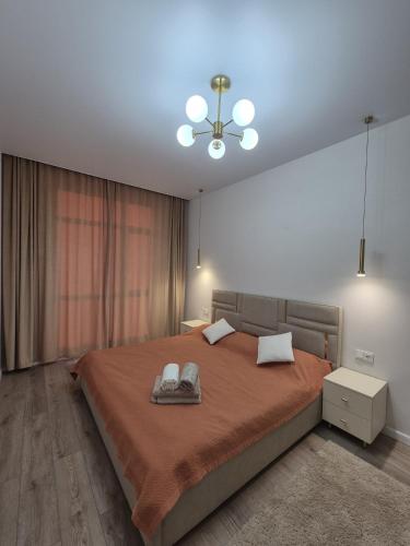 a bedroom with a large bed and a ceiling fan at ЖК Geneva in Astana