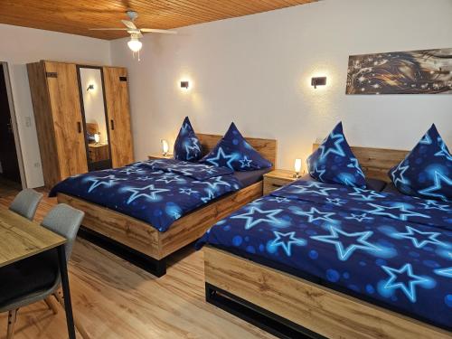 two beds in a room with blue sheets at Pension Haus Erika in Cuxhaven