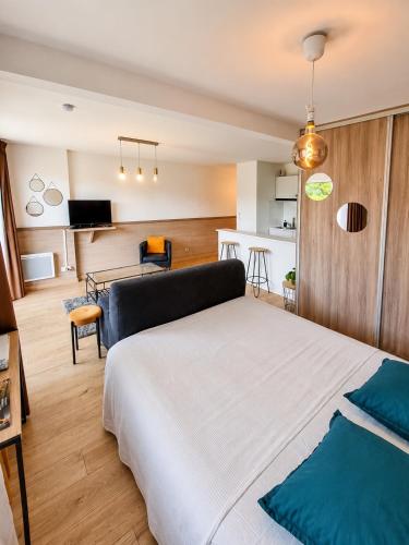 a bedroom with a bed and a living room at Appart Omaha Beach in Port-en-Bessin-Huppain
