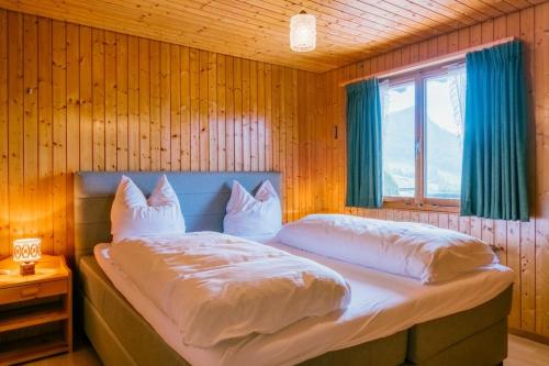 a bedroom with a bed with white sheets and pillows at Apartment Bergdohle in Amden