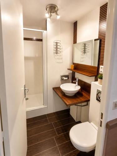 a bathroom with a white toilet and a sink at Appart Omaha Beach in Port-en-Bessin-Huppain