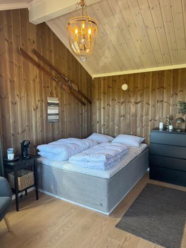 a bedroom with a bed in a wooden wall at Vikerfjell i Ringerike, Oslos nærmeste høyfjell in Hønefoss