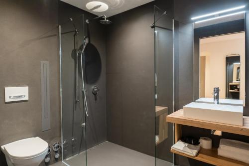 ein Badezimmer mit Dusche, Toilette und Waschbecken in der Unterkunft Pattùs Hôtel in Saint Aubin Sauges